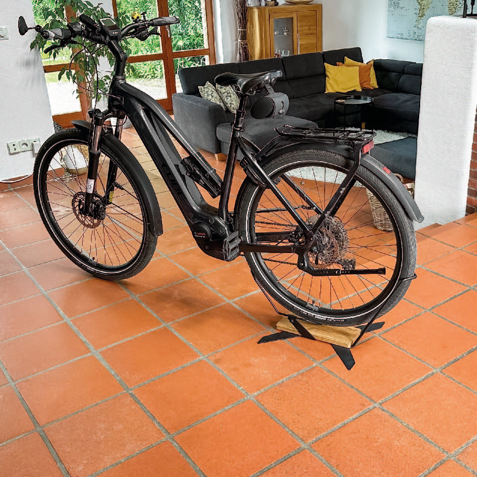 X-STAND mit E-BIKE im Wohnzimmer auf terracotta Fliesen